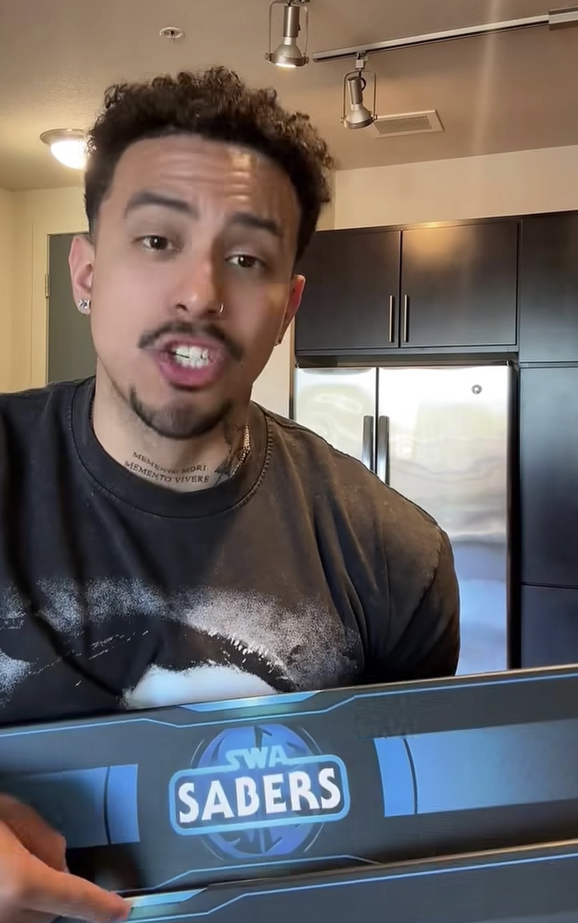 Adult man creator presenting an SWA Sabers package in a home studio